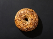 Overhead view of bagel with seeds on black background