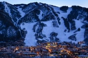 Dusk image of glowing lights in town and cut ski runs and slopes above. Scenic view with copy space. Captured as a 14-bit Raw file. Edited in 16-bit ProPhoto RGB color space.