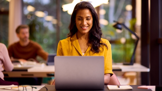 A woman sat in front of a laptop