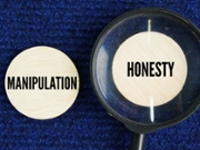 Magnifying glass with the words manipulation and honesty. two opposite ways of communicating and treating other people.