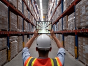 Foreman with tablet taking photos of the warehouse.
