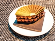 Eating luxury chocolate dessert with gold design.