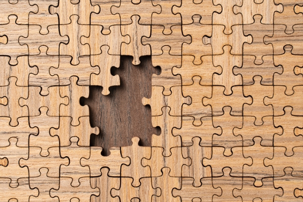 Wooden Jigsaw Puzzle About to Be Finished With a Blank Area Close-up Full Frame View.