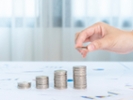 hand holding stack money coins to show concept of growing business.