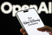 In this photo illustration, a smartphone displays the logo of The Walt Disney Co. with the OpenAI logo visible in the background.