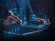 AI Business Analyst Collaborating with Virtual AI Agent to Analyze Big Data in Real Time on a Holographic Dashboard with Computers and Laptops in a Dark Blue-Lit Room