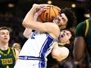 GREENVILLE, SOUTH CAROLINA - MARCH 19: Cameron Boozer #12 of the Duke Blue Devils battles Riley Mulvey #55 of the Siena Saints for the ball during the second half in the first round of the 2026 NCAA Men's Basketball Tournament at Bon Secours Wellness Arena on March 19, 2026 in Greenville, South Carolina. (Photo by Jared C. Tilton/Getty Images)