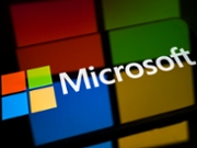 The Microsoft logo is displayed on a smartphone screen placed on a reflective surface onto which the company's logo is projected, in Creteil, France, on May 4, 2026. The Pentagon has signed agreements to integrate AI into its classified networks. (Photo by Samuel Boivin/NurPhoto via Getty Images)