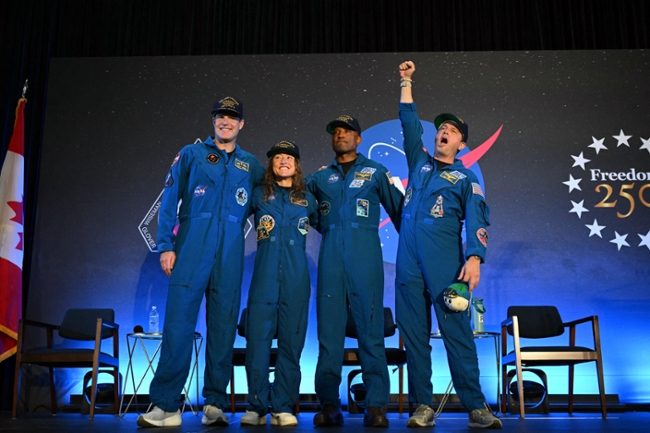 TOPSHOT - (L-R) NASA's Artemis II mission astronauts Canadian Space Agency's Jeremy Hansen, mission specialist Christina Koch, pilot Victor Glover and commander Reid Wiseman attend a welcoming ceremony at Ellington Field Joint Reserve Base in Houston, Texas, on April 11, 2026. An elated NASA late April 10 was celebrating its successful voyage around the Moon, after four astronauts safely returned to Earth having completed the first lunar flyby in more than 50 years. The NASA spacecraft carrying four astronauts -- three Americans and one Canadian -- splashed down without a hitch off the California coast, capping the US space agency's crewed test mission that returned with spectacular images of the Moon. (Photo by RONALDO SCHEMIDT / AFP via Getty Images)