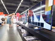 Woman chooses TV in electronic shop