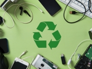 E-waste recycling concept. Old electronics like phones, headphones, hard drive, and cables surround a green recycling symbol on a green background.
