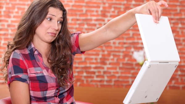 A woman looking with disdain at a laptop