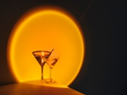 Creative image of martini cocktail glass on orange neon light in nightclub bar