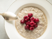 homemade rustic healthy breakfast styled concept - oatmeal with raspberries and honey, elegant visuals
