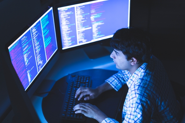 Technology, Cyber Security, Identity Protection - Overhead image of a Young man working on an advance computer system using multiple screens