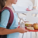 Girl carrying lunch tray at school