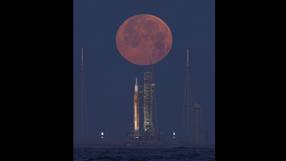 Stunning pink moon sets behind Artemis 1 just before it rolls off the pad