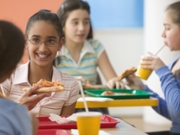 Four girls eating pizza in cafeteria